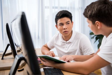 teen boy tutoring another student for a summer job
