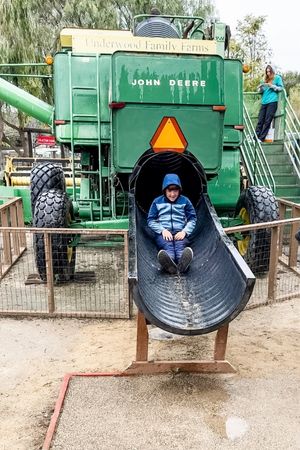 boy on slide made from farm equipment