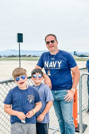 Navy dad and sons in front of blue angel fat albert