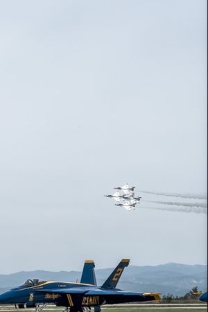 thunderbirds in formation flying over blue angel planes