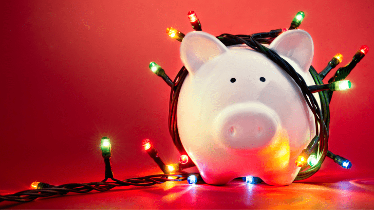 Piggy bank wrapped in Christmas lights showing a budget friendly, frugal Christmas